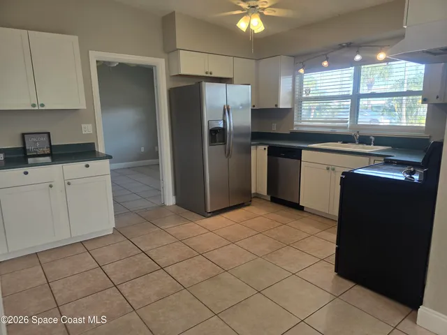 a kitchen with stainless steel appliances granite countertop a refrigerator sink and cabinets