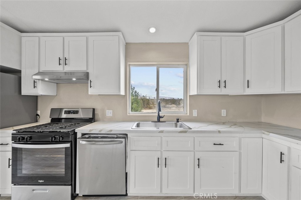 6142 Rare Rabbit Avenue Mojave, CA 93501 - Photo 23 of 50 a kitchen with granite countertop white cabinets and white stainless steel appliances