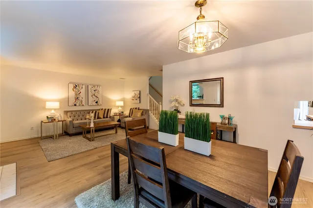 a view of a dining room with furniture a chandelier and wooden floor