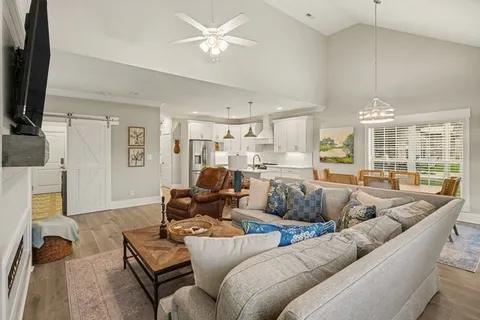 a living room with furniture wooden floor and a flat screen tv
