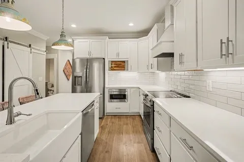 a kitchen with a sink a counter top space stainless steel appliances and cabinets