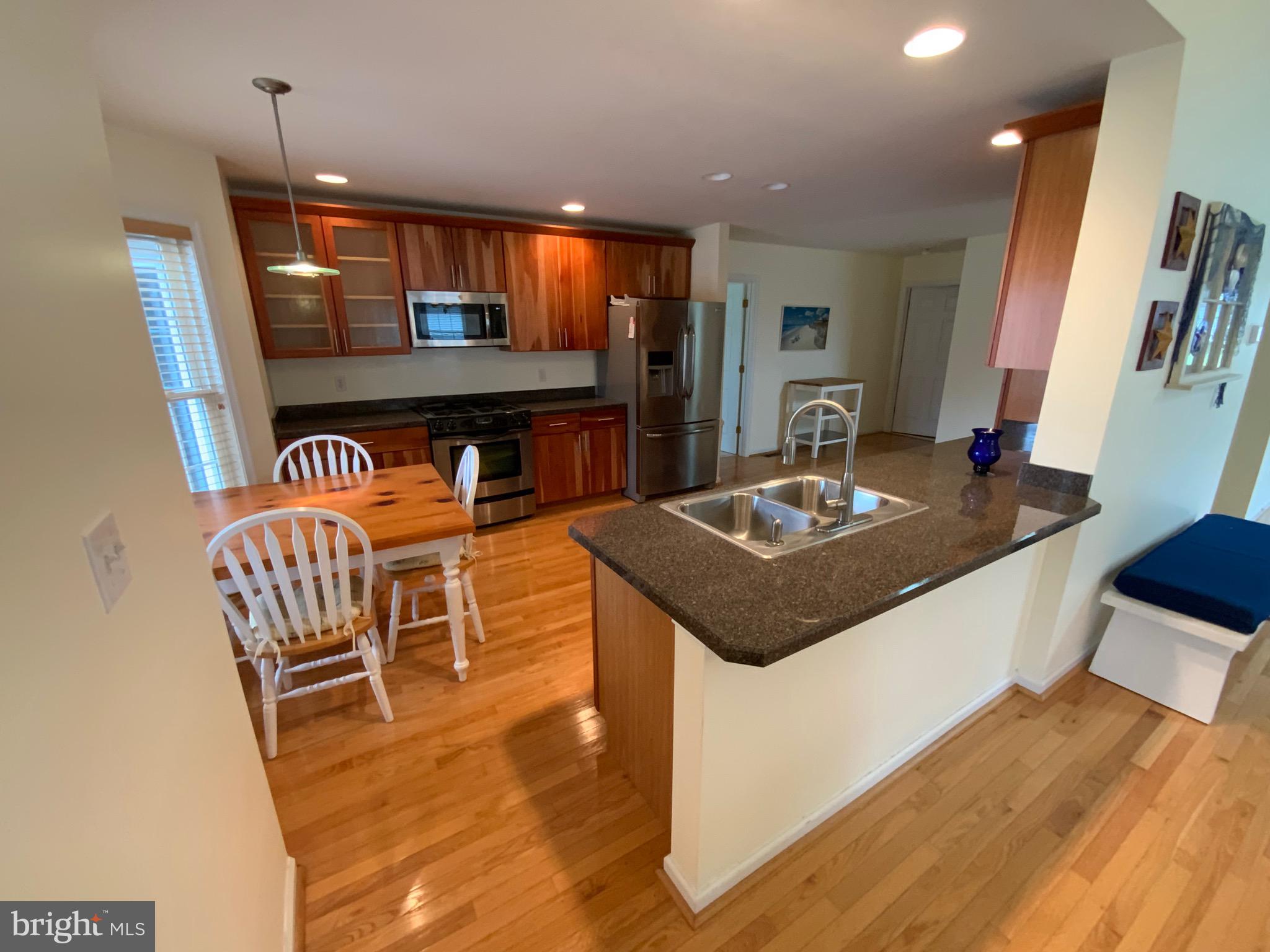 38211 Marlington Road Ocean View, DE 19970 - Photo 12 of 56 a kitchen with a table chairs and a refrigerator