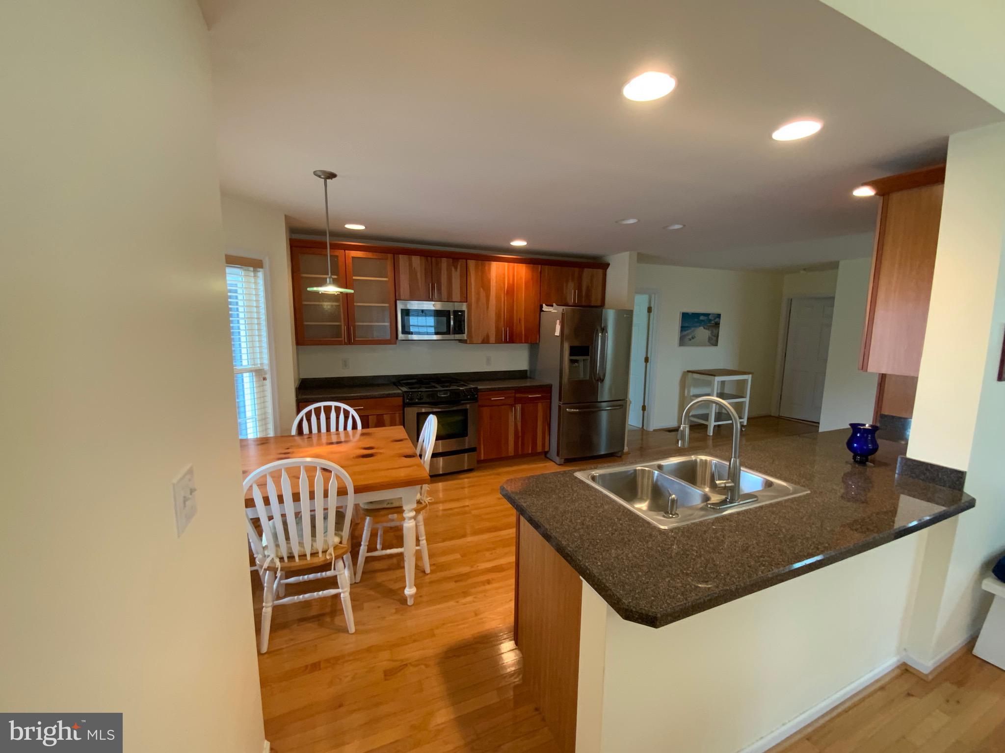 38211 Marlington Road Ocean View, DE 19970 - Photo 13 of 56 a kitchen with a table chairs and flat screen tv