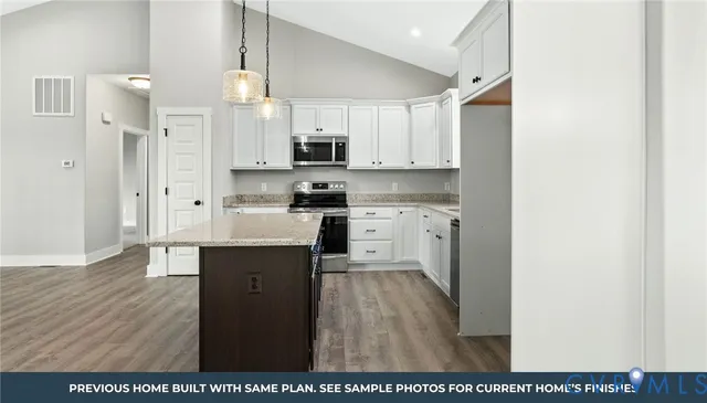 a kitchen with stainless steel appliances a sink a stove a refrigerator and cabinets