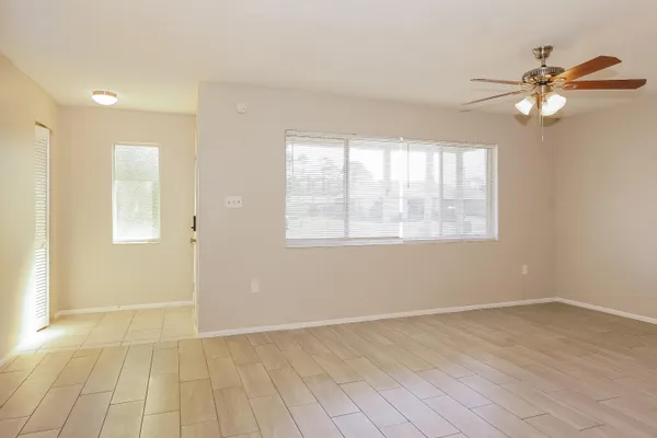 an empty room with a window and a fan