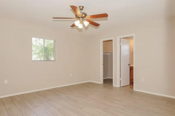 an empty room with windows and fan