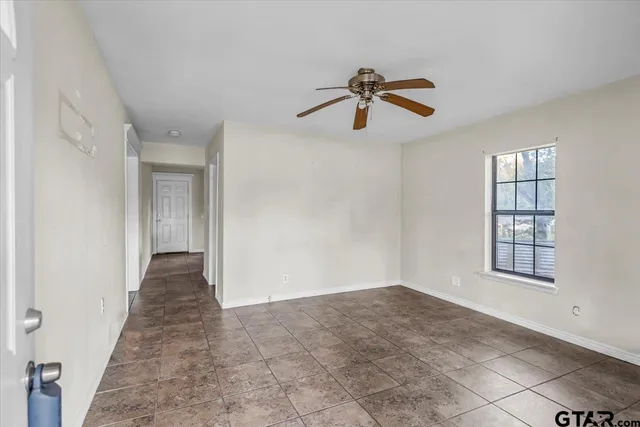 a view of empty room with windows and ceiling fan
