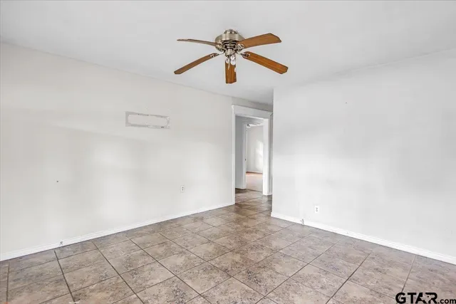 a view of empty room with ceiling fan