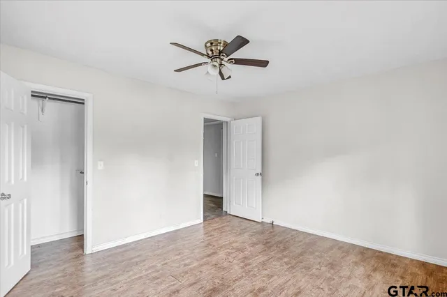 a view of a room with wooden floor and ceiling fan