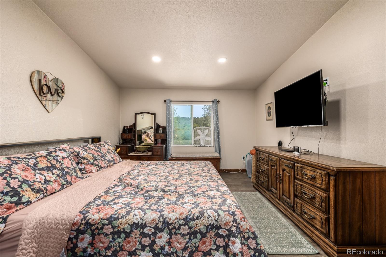 752 Impala Trail Bailey, CO 80421 - Photo 16 of 50 a bedroom with a bed and a flat screen tv