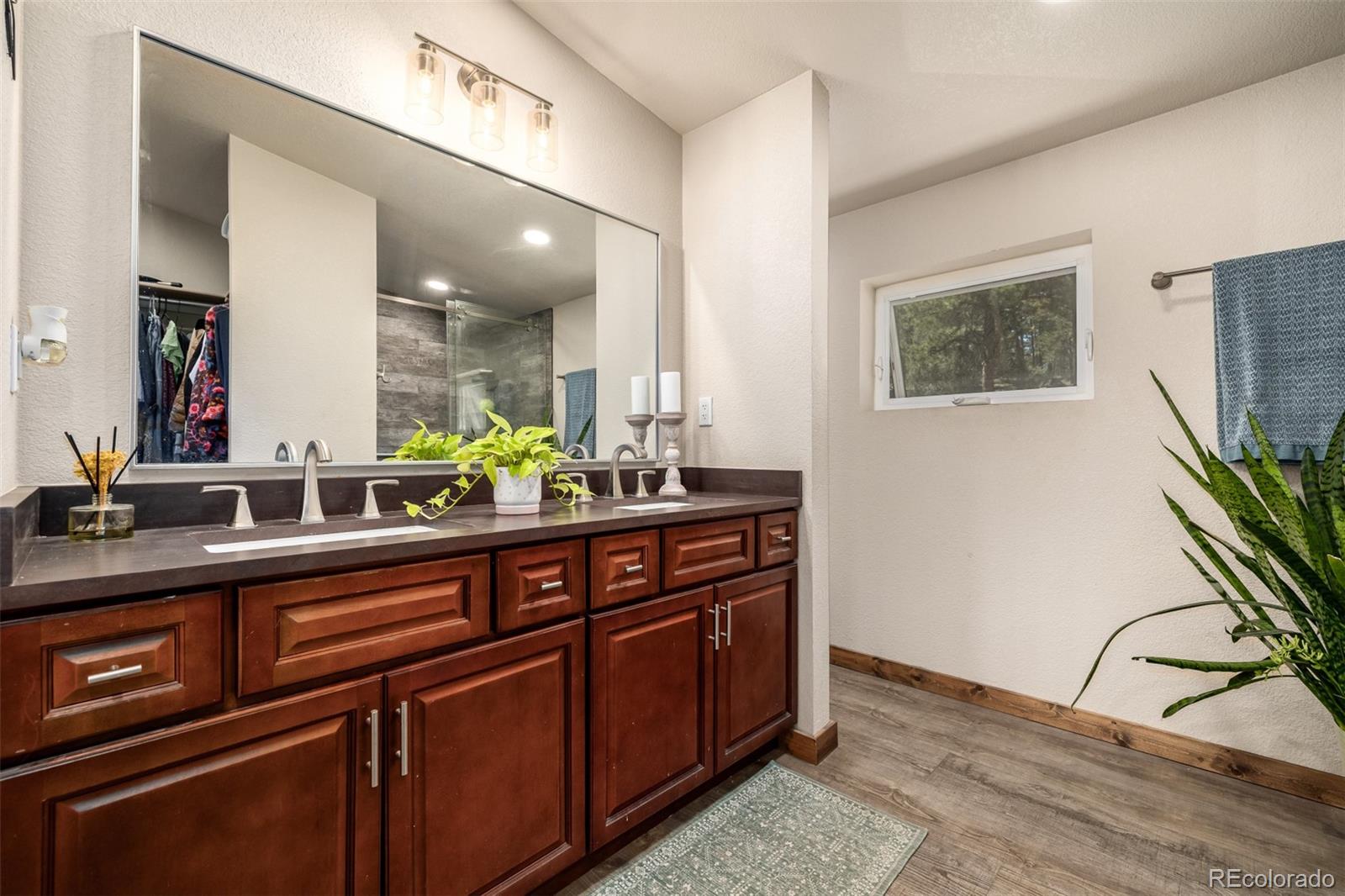 752 Impala Trail Bailey, CO 80421 - Photo 18 of 50 a view of a sink a mirror and wooden floor