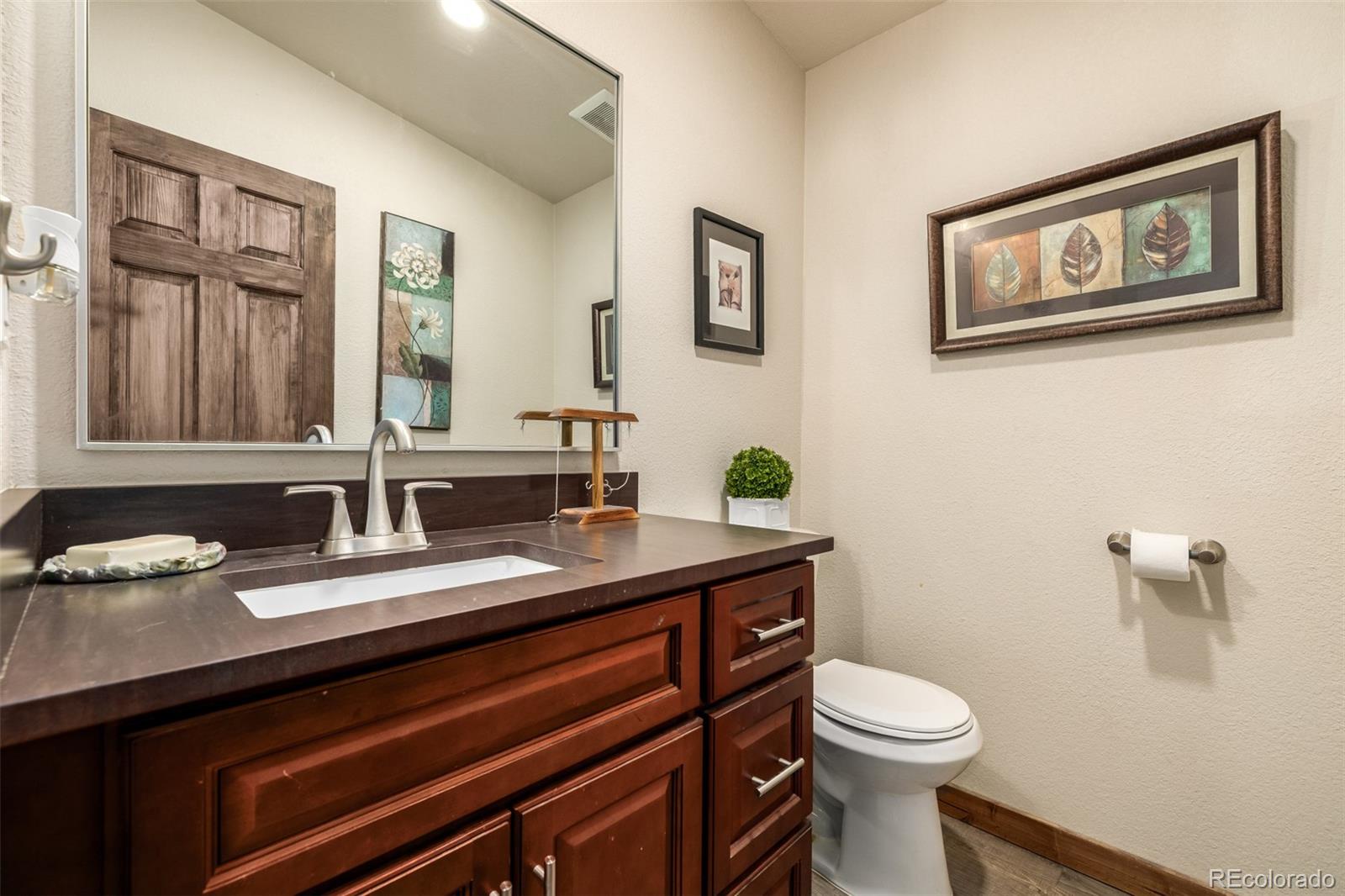 752 Impala Trail Bailey, CO 80421 - Photo 22 of 50 a bathroom with a granite countertop toilet sink and mirror