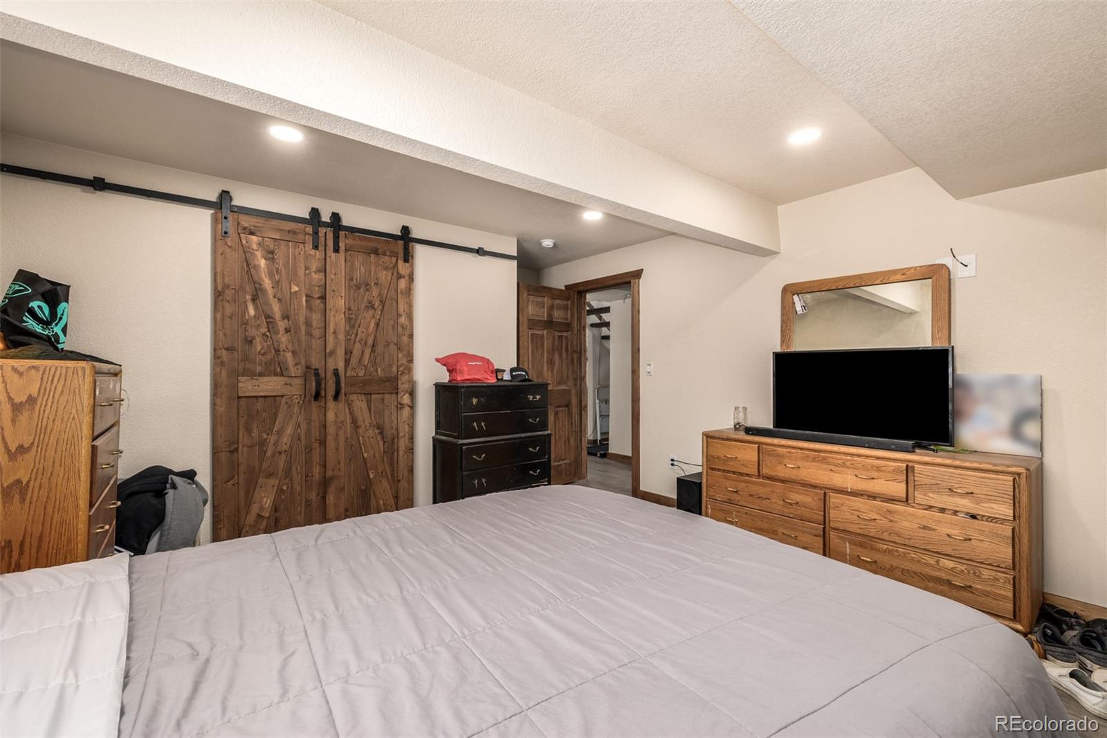 752 Impala Trail Bailey, CO 80421 - Photo 24 of 50 a bedroom with a bed and a flat tv screen on dresser