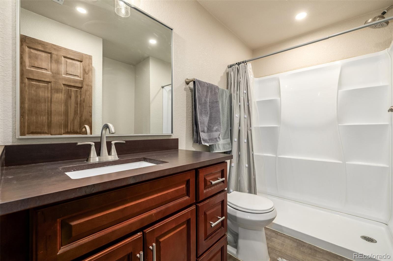 752 Impala Trail Bailey, CO 80421 - Photo 25 of 50 a bathroom with a double vanity sink toilet mirror and shower