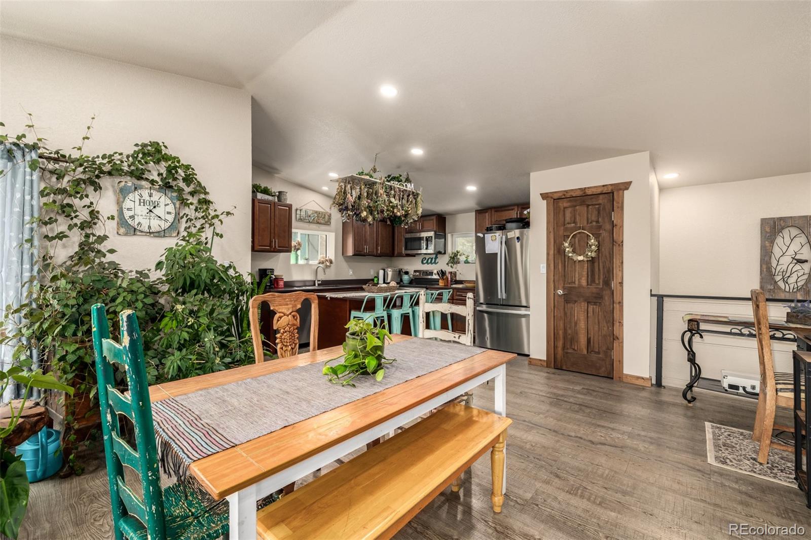 752 Impala Trail Bailey, CO 80421 - Photo 9 of 50 a kitchen with stainless steel appliances kitchen island granite countertop a refrigerator a stove a microwave oven a dining table and chairs with wooden floor