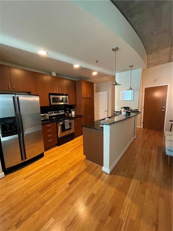a kitchen with stainless steel appliances wooden floors and wooden cabinets