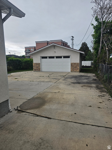 444 South 100 East Springville, UT 84663 - Photo 21 of 28 Detached garage featuring a white sectional door, stucco exterior, and stone veneer accents