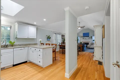 a large kitchen with stainless steel appliances granite countertop a sink and dishwasher a stove with wooden floor