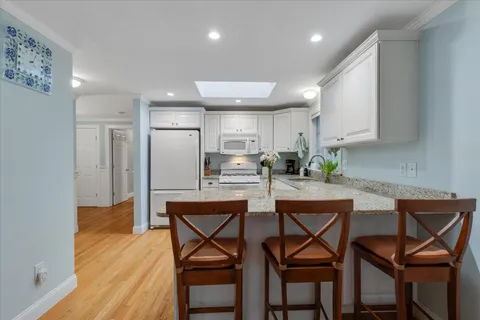 a kitchen with a refrigerator a stove a sink and white cabinets