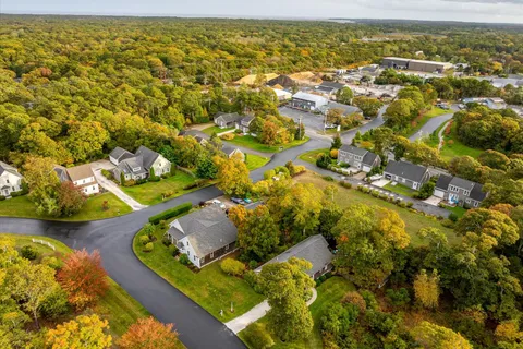 a aerial view of a house with a yard and large trees