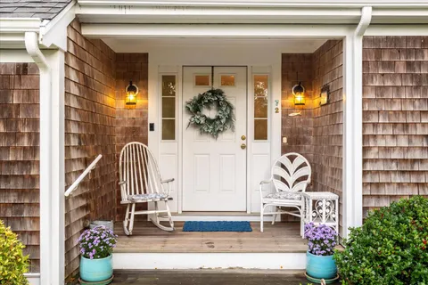 a hallway with a dining table a chandelier and a window