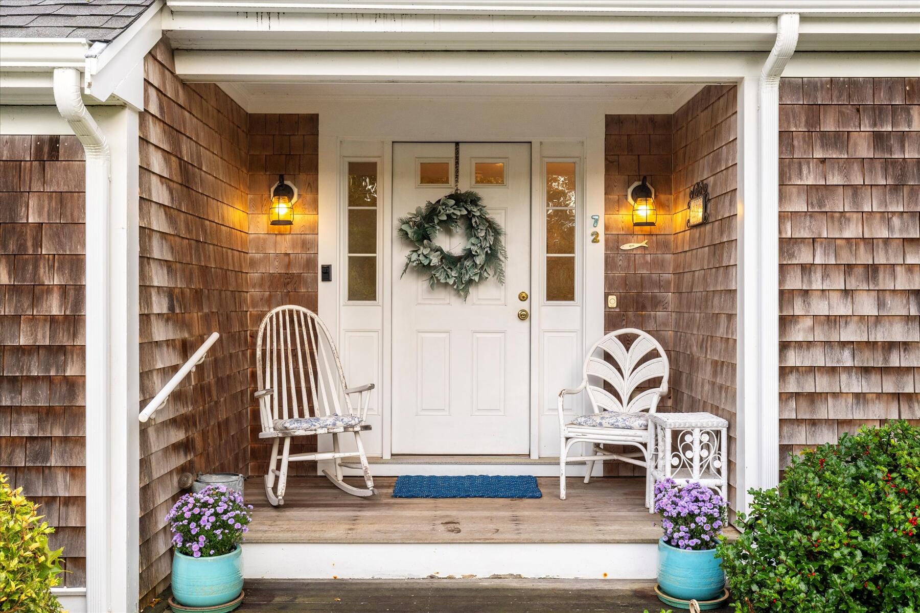 72 Dory Lane Eastham, MA 02642 - Photo 5 of 57 a front view of a house with outdoor seating and a potted plant