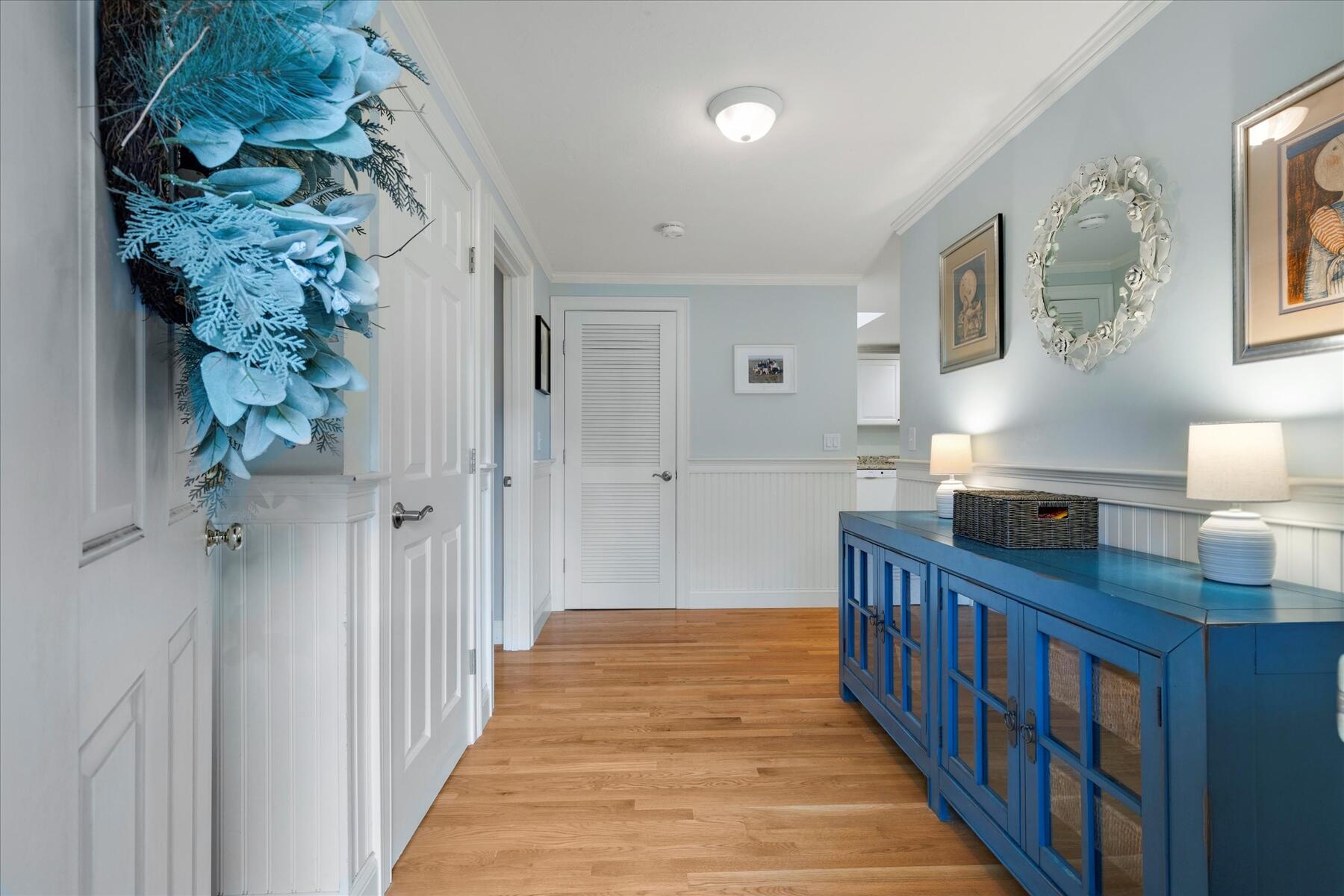 72 Dory Lane Eastham, MA 02642 - Photo 6 of 57 a hallway with a dining table a chandelier and a window