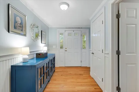 a view of a hallway with wooden floor and cabinet