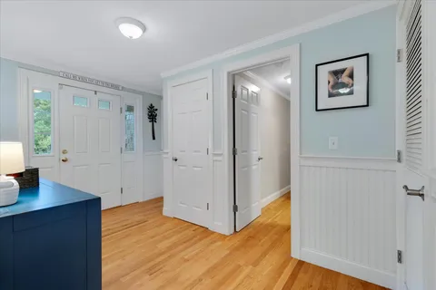 a view of a hallway with wooden floor and a living room