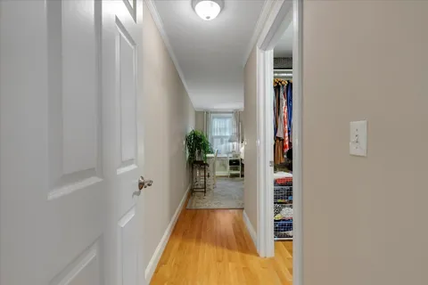 a bedroom with a bed table flowerpot and window