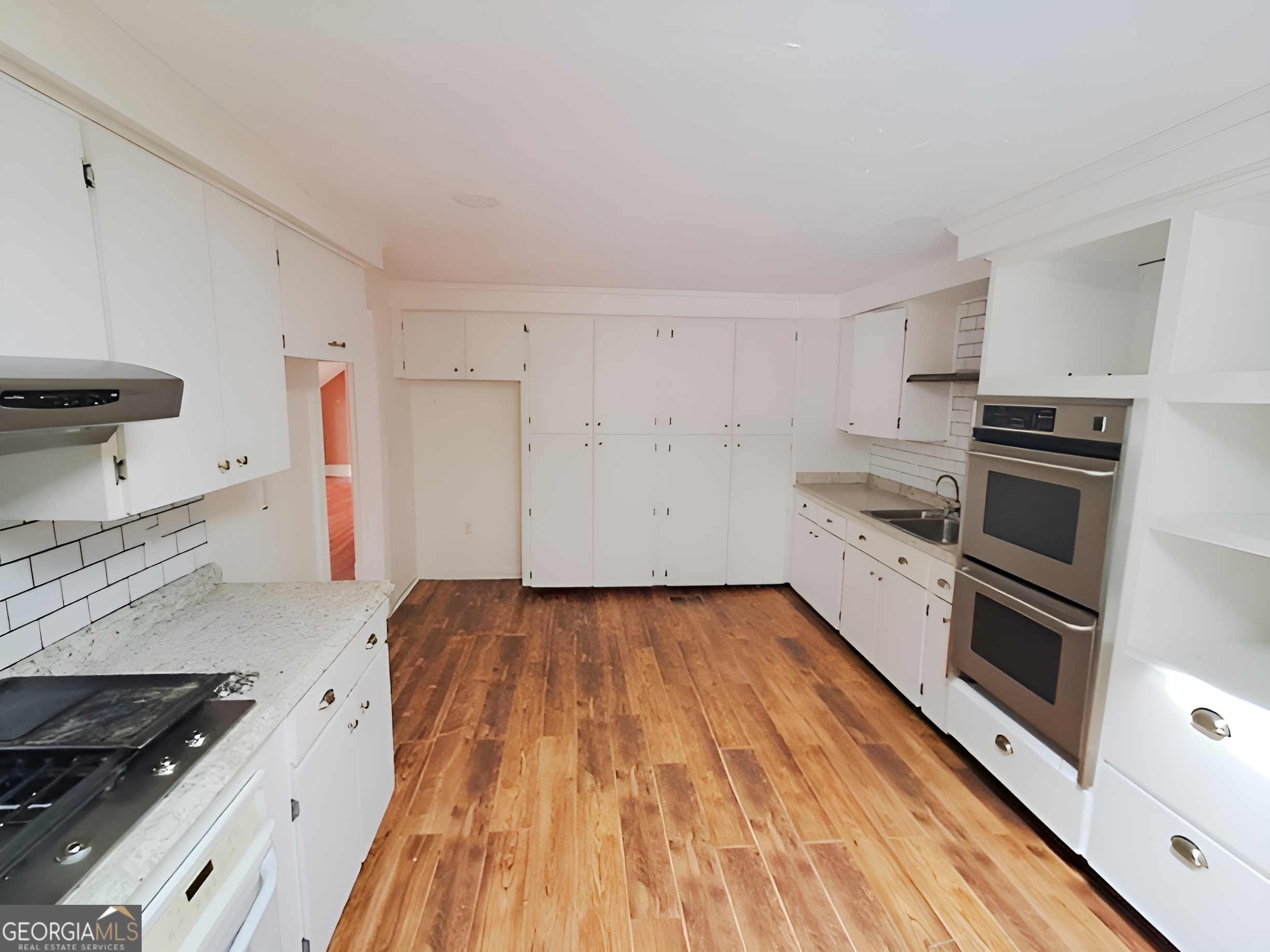 401 Forsyth Street Barnesville, GA 30204 - Photo 11 of 25 a kitchen with granite countertop a refrigerator and a stove top oven