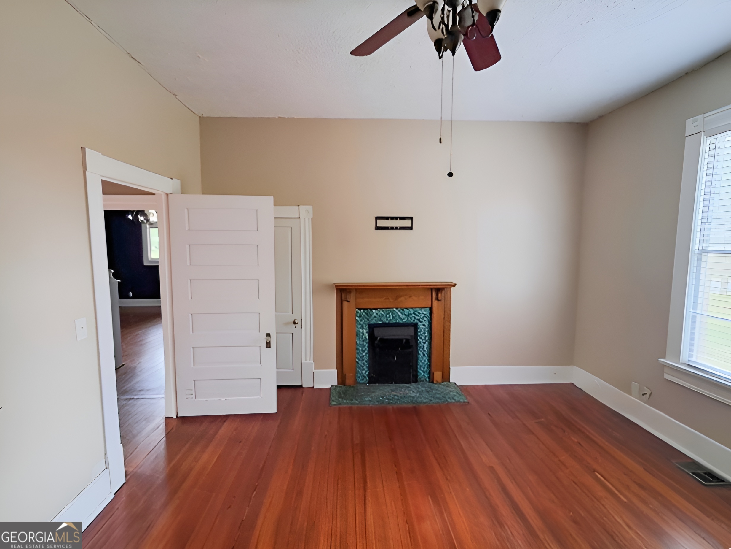 401 Forsyth Street Barnesville, GA 30204 - Photo 14 of 25 an empty room with wooden floor fireplace and windows