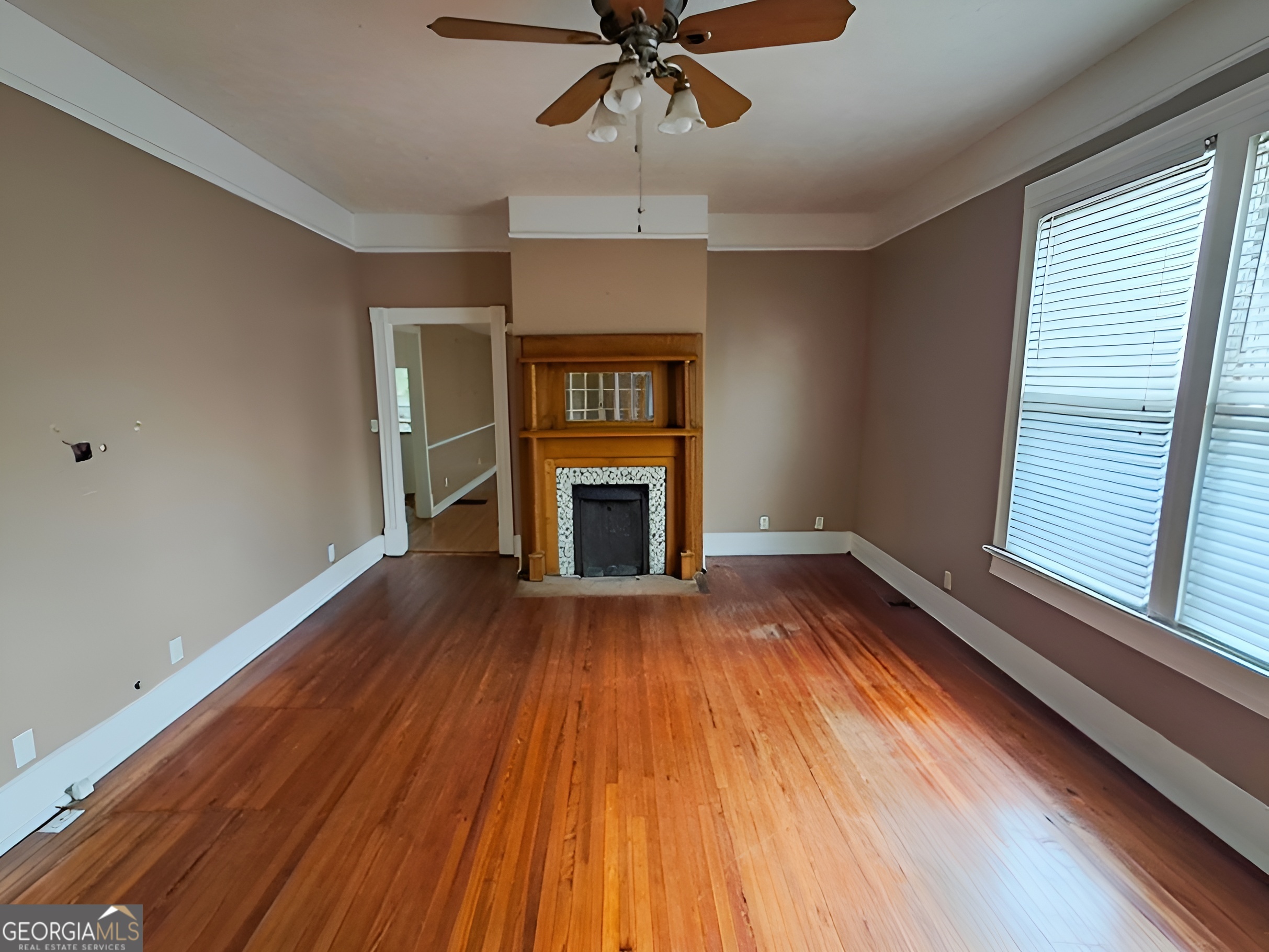 401 Forsyth Street Barnesville, GA 30204 - Photo 8 of 25 a view of an empty room with wooden floor fireplace and a window