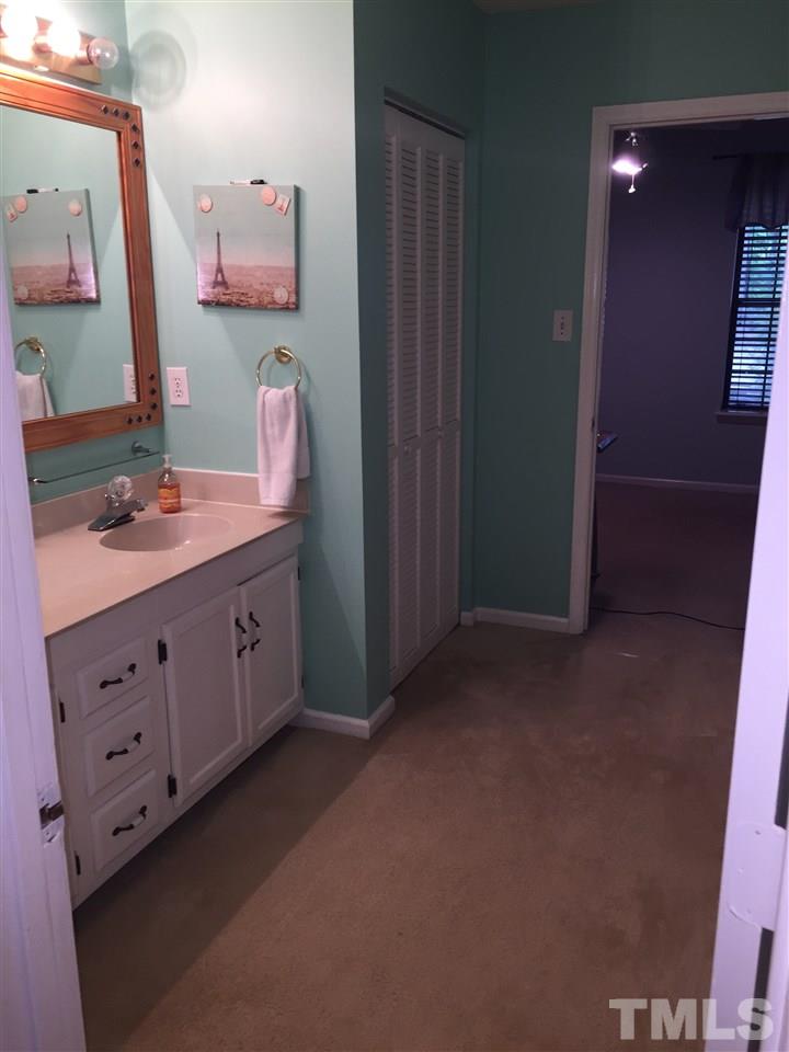 5702 3 Oaks Drive Raleigh, NC 27612 - Photo 13 of 18 a bathroom with a double vanity sink a mirror and a shower