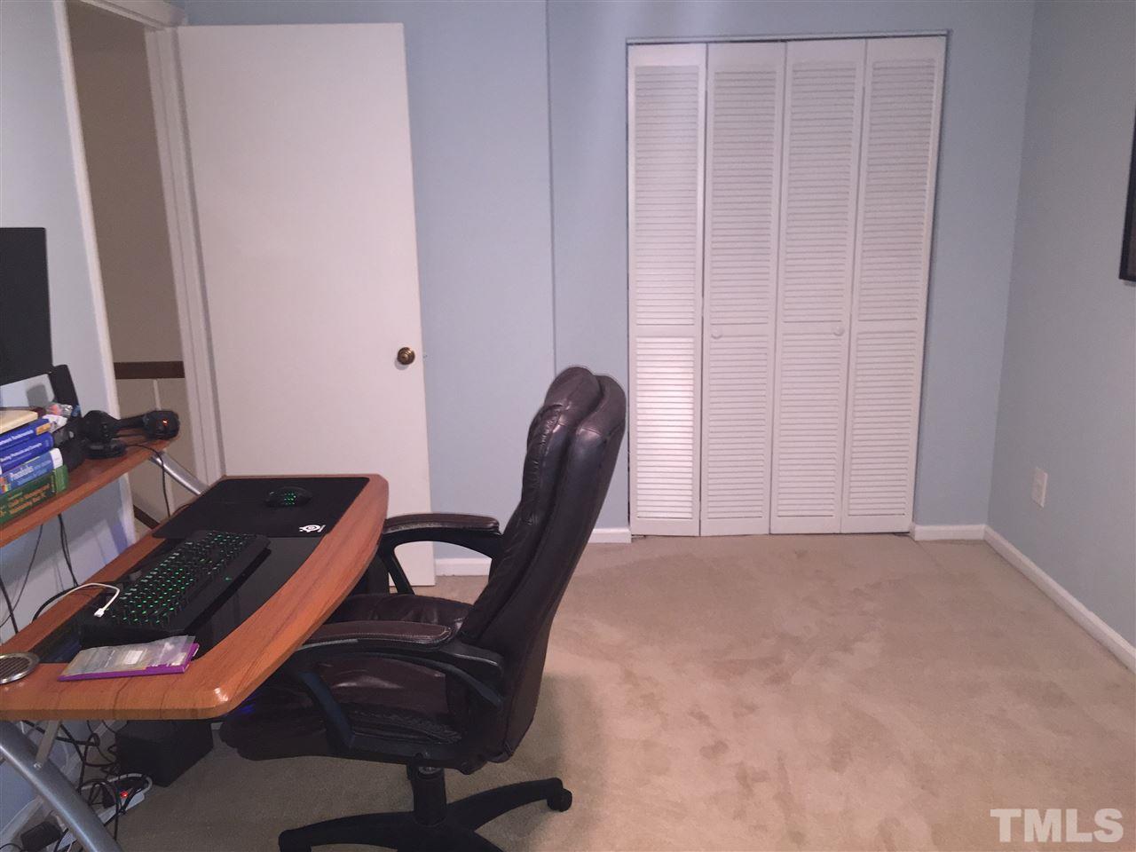 5702 3 Oaks Drive Raleigh, NC 27612 - Photo 16 of 18 a view of a workspace with furniture and a gate