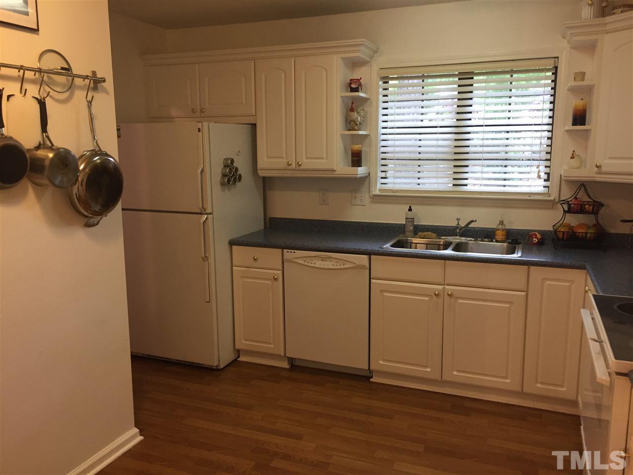 5702 3 Oaks Drive Raleigh, NC 27612 - Photo 4 of 18 a kitchen with a refrigerator and white cabinets