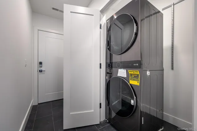a view of a bathroom with washing machine and mirror