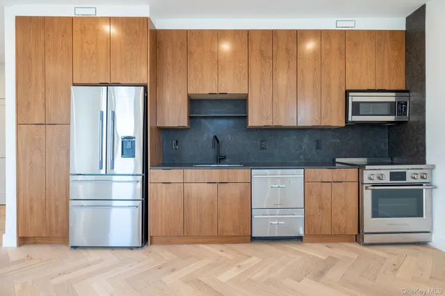 a kitchen with stainless steel appliances granite countertop a refrigerator a stove a sink and dishwasher