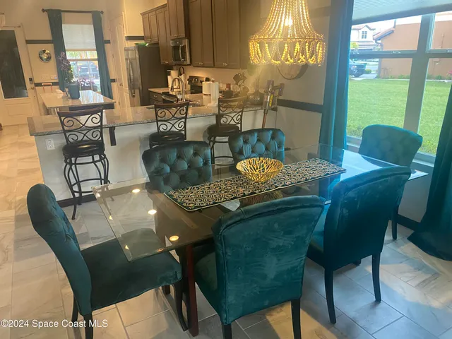a dining room with furniture and a floor to ceiling window