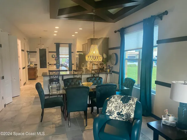 a dining room with furniture a chandelier and pool table