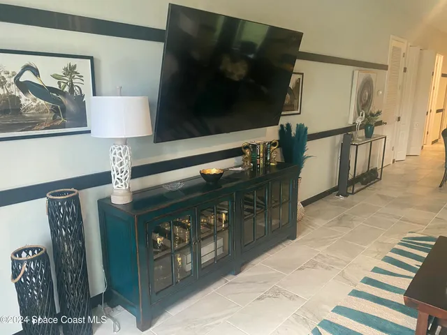 a living room with chairs and a flat screen tv