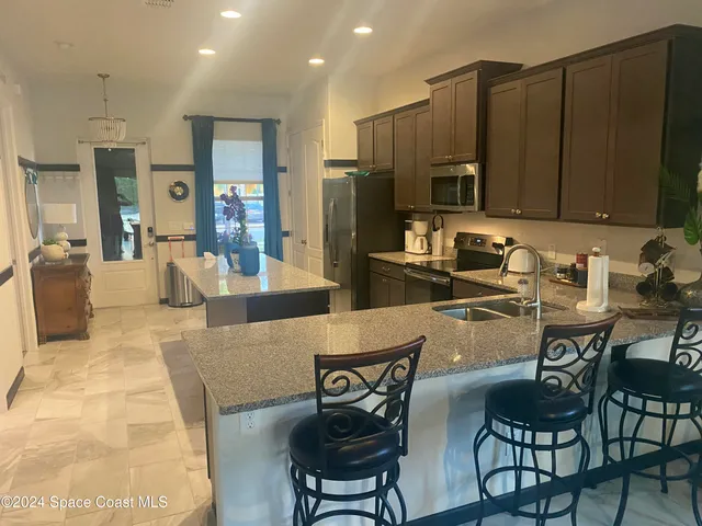 a kitchen with stainless steel appliances wooden cabinets dining table and chairs