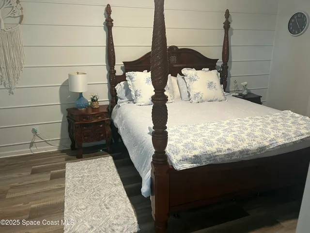 a bed sitting in a bedroom and wooden floor