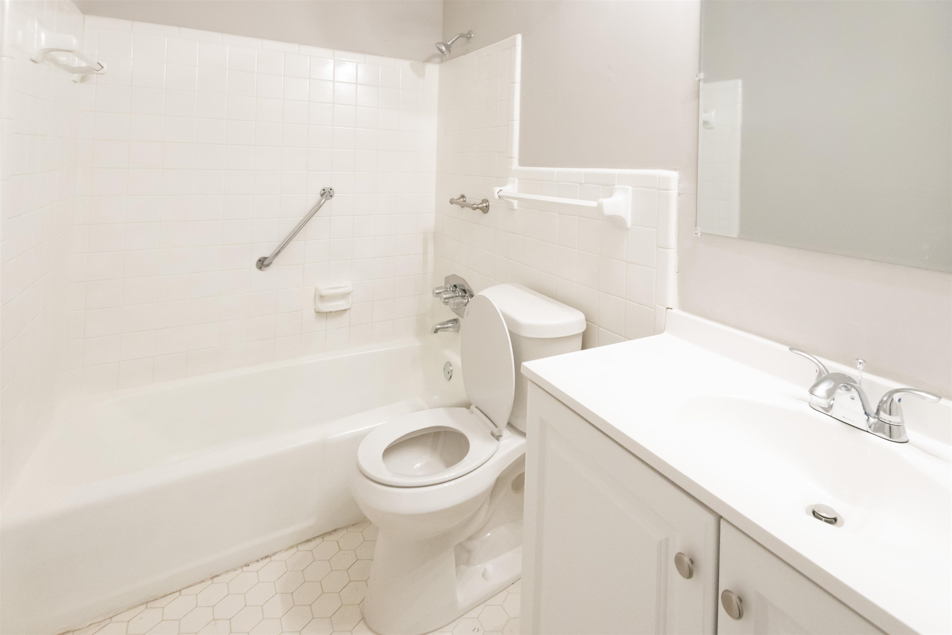 4399 Pepper Tree Road Memphis, TN 38109 - Photo 11 of 14 White tiled bath and shower combination with grab bar