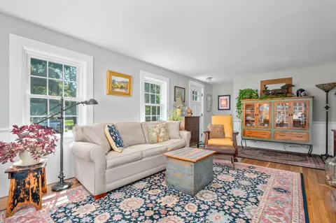 a living room with furniture a rug and a window