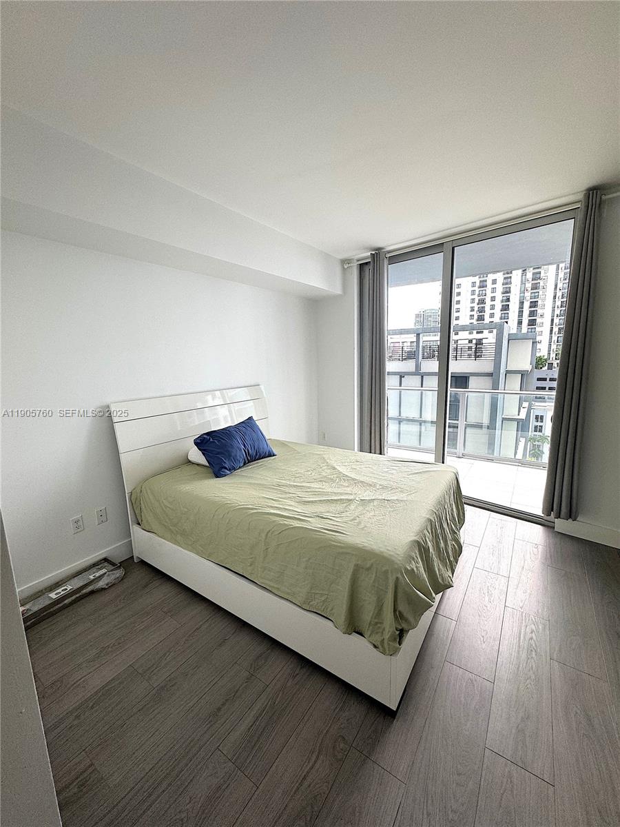 1010 Southwest 2nd Avenue, Unit 910 Miami, FL 33130 - Photo 14 of 32 a bedroom with a bed and wooden floor