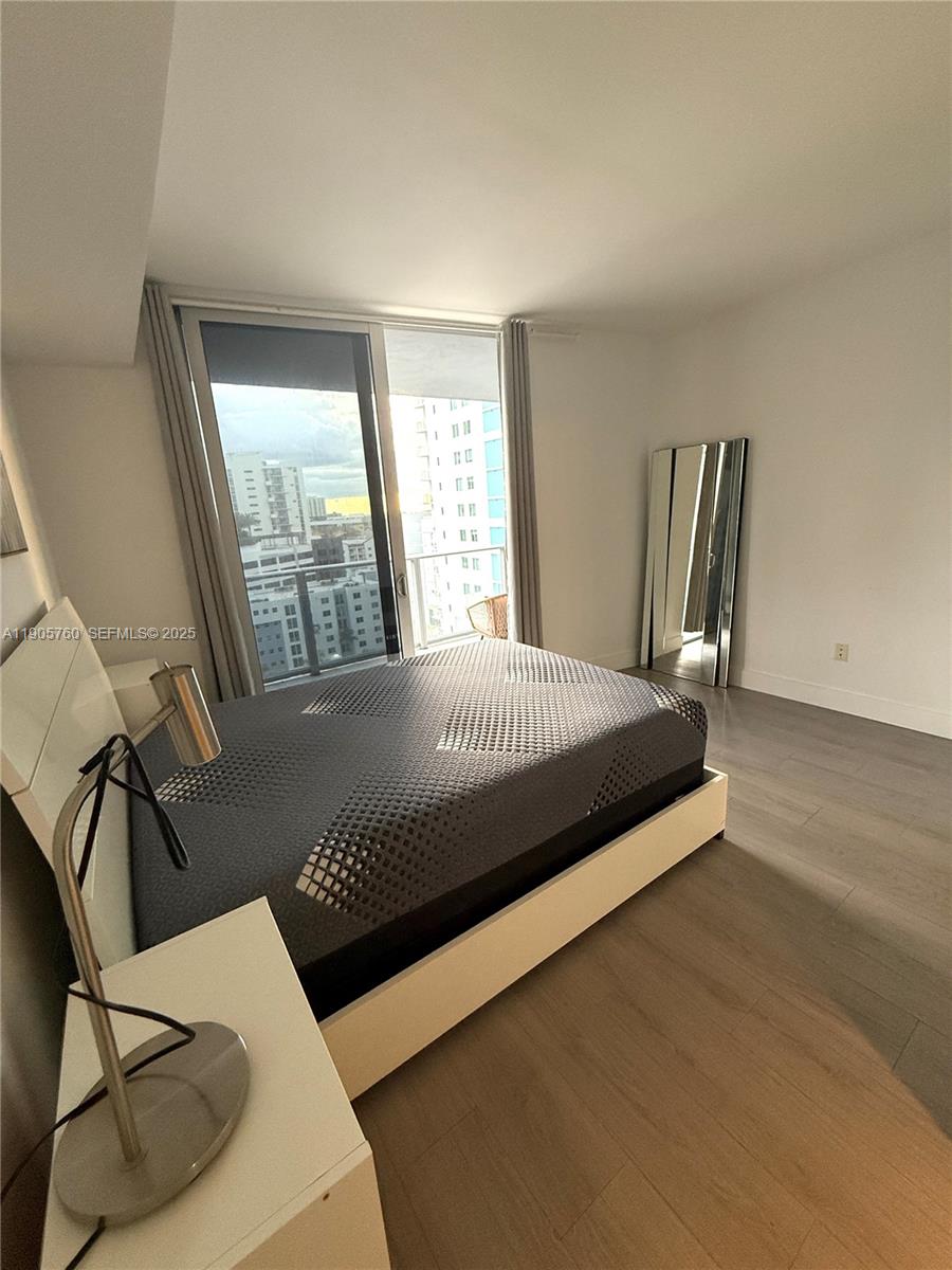 1010 Southwest 2nd Avenue, Unit 910 Miami, FL 33130 - Photo 23 of 32 a bedroom with a bed two lamps and a large window