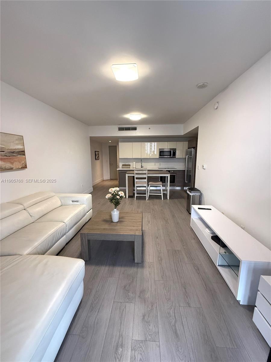 1010 Southwest 2nd Avenue, Unit 910 Miami, FL 33130 - Photo 3 of 32 a living room with furniture and a wooden floor