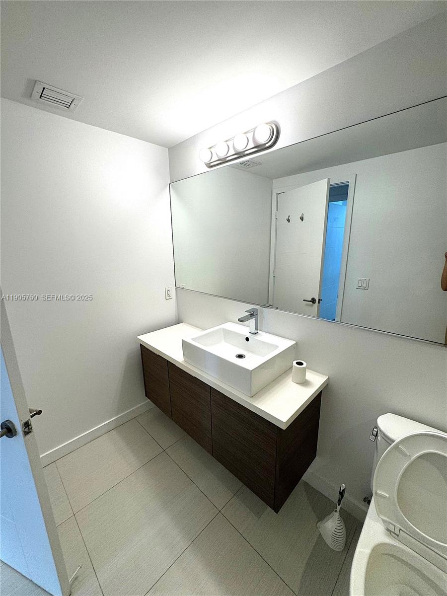 1010 Southwest 2nd Avenue, Unit 910 Miami, FL 33130 - Photo 8 of 32 a bathroom with a sink toilet and mirror