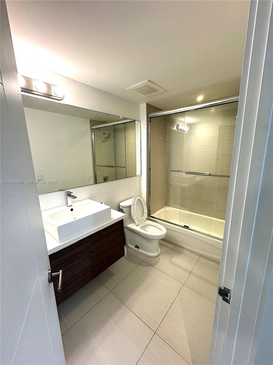 1010 Southwest 2nd Avenue, Unit 910 Miami, FL 33130 - Photo 9 of 32 a bathroom with a bathtub shower sink and mirror